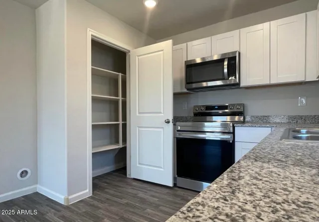 a kitchen with stainless steel appliances granite countertop a refrigerator and a stove top oven