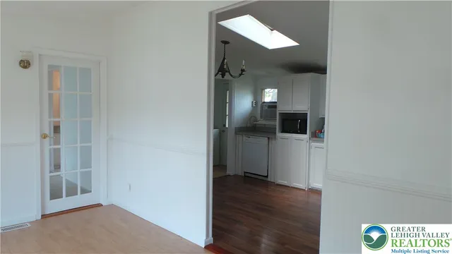 a view of a hallway with wooden floor and a bathroom