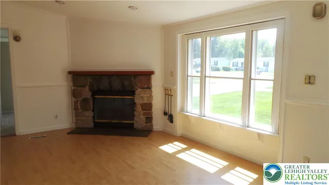 a view of an empty room with a fireplace and a window