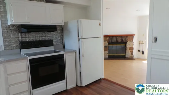 a kitchen with a refrigerator and a stove top oven