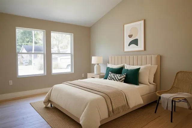 a spacious bedroom with a bed and wooden floor