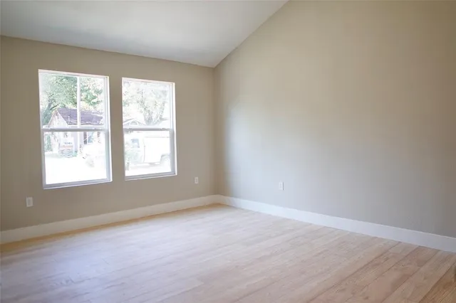 an empty room with wooden floor and closet
