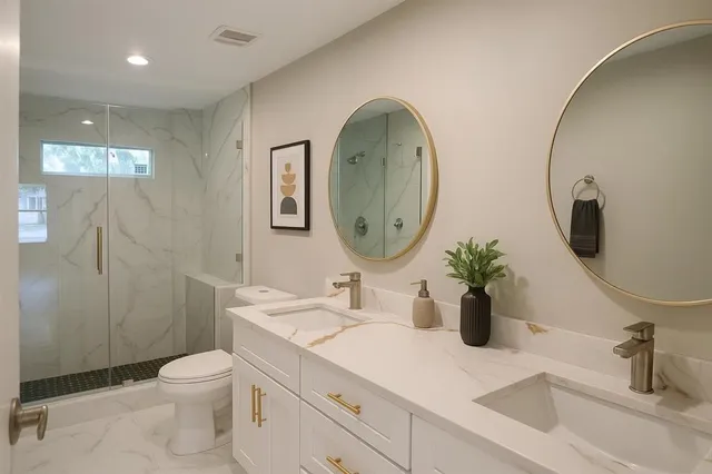 a en suite bathroom with a double vanity sink and a mirror