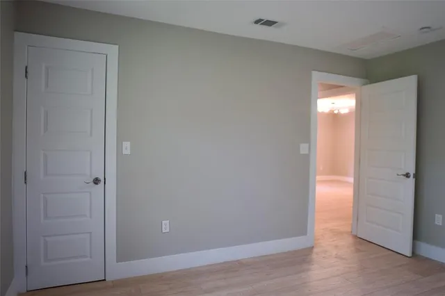a view of a big room with wooden floor and windows