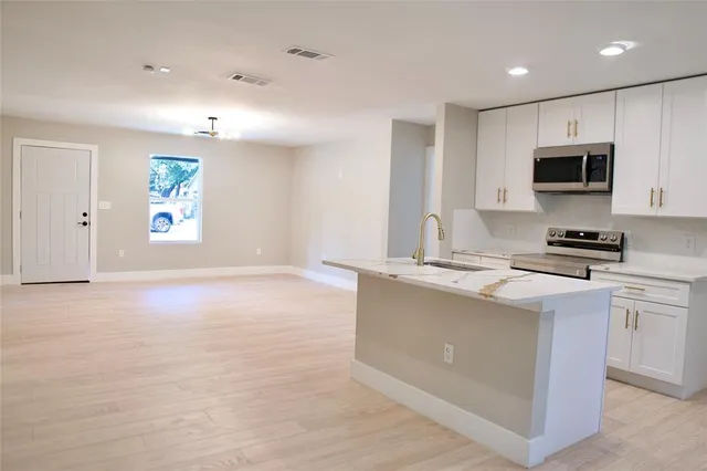 a kitchen with stainless steel appliances granite countertop a stove a sink and a refrigerator