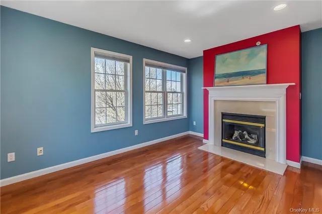 a view of an empty room with a fireplace and a window