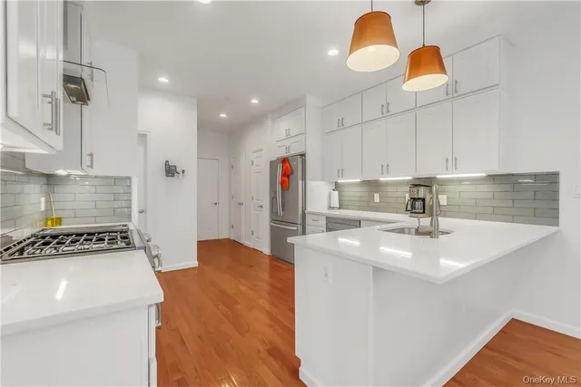 a kitchen with stainless steel appliances granite countertop a sink a stove and a refrigerator