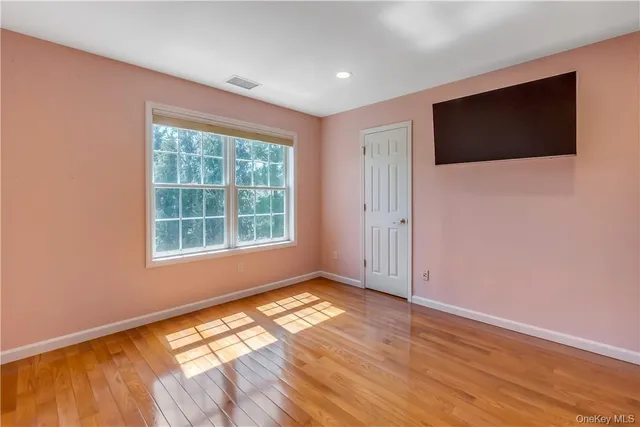 en empty room with window and wooden floor