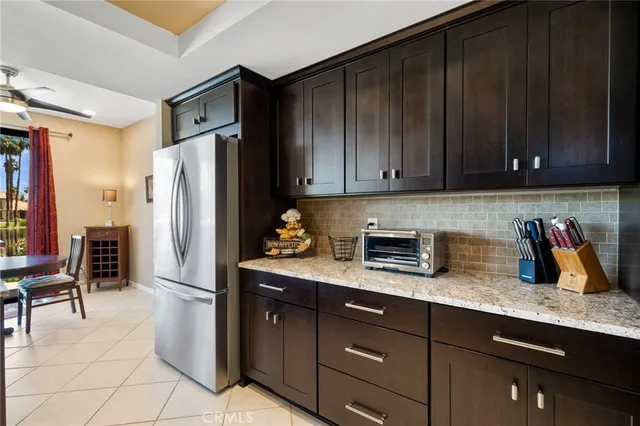 a kitchen with granite countertop wooden cabinets a refrigerator and a sink