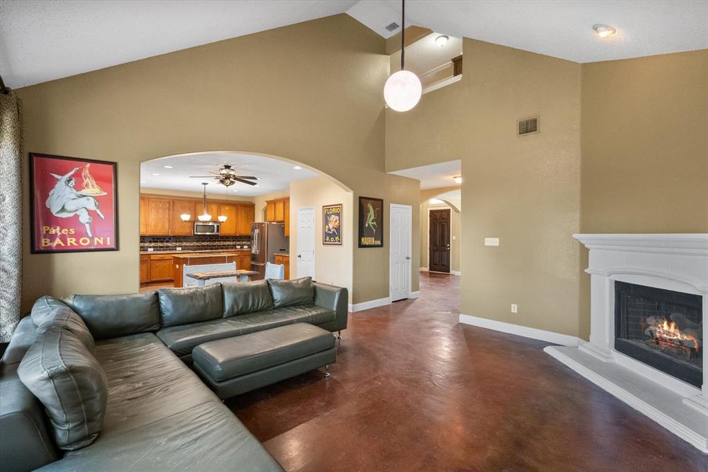1305 Liverpool Lane Mansfield, TX 76063 - Photo 12 of 40 Living area featuring high vaulted ceilings, a fireplace with a white mantel, and rich-toned flooring