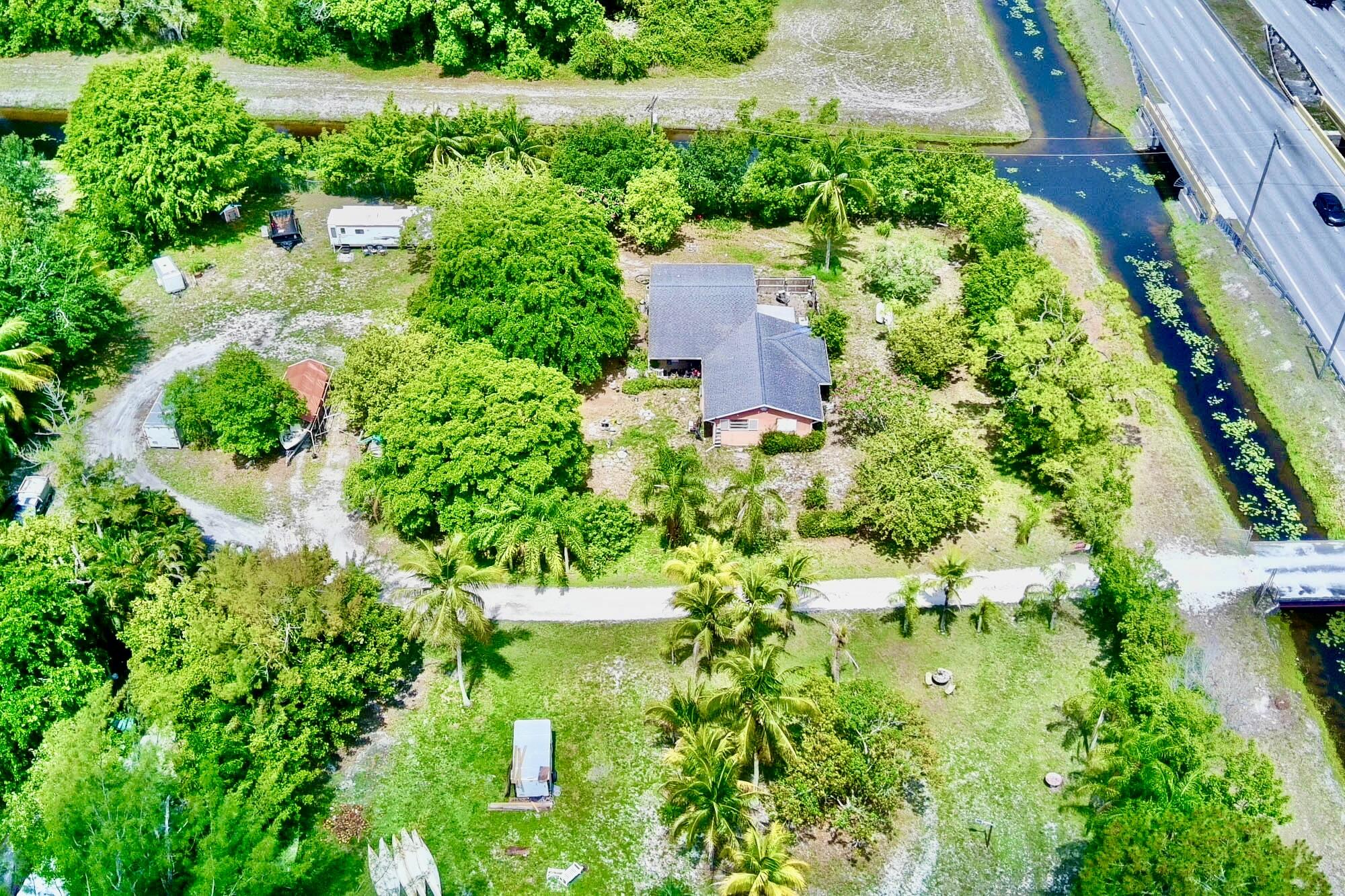 5947 Hypoluxo Road Lake Worth, FL 33463 - Photo 4 of 7 an aerial view of residential house with outdoor space and trees all around