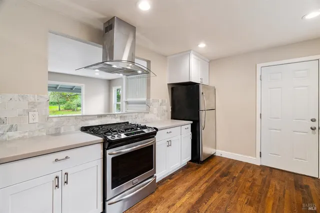 a kitchen with stainless steel appliances granite countertop a stove and a refrigerator