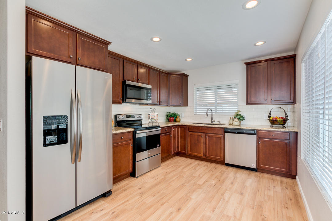 6320 Casper Road Mesa, AZ 85205 - Photo 11 of 35 a kitchen with stainless steel appliances granite countertop a refrigerator stove top oven and sink