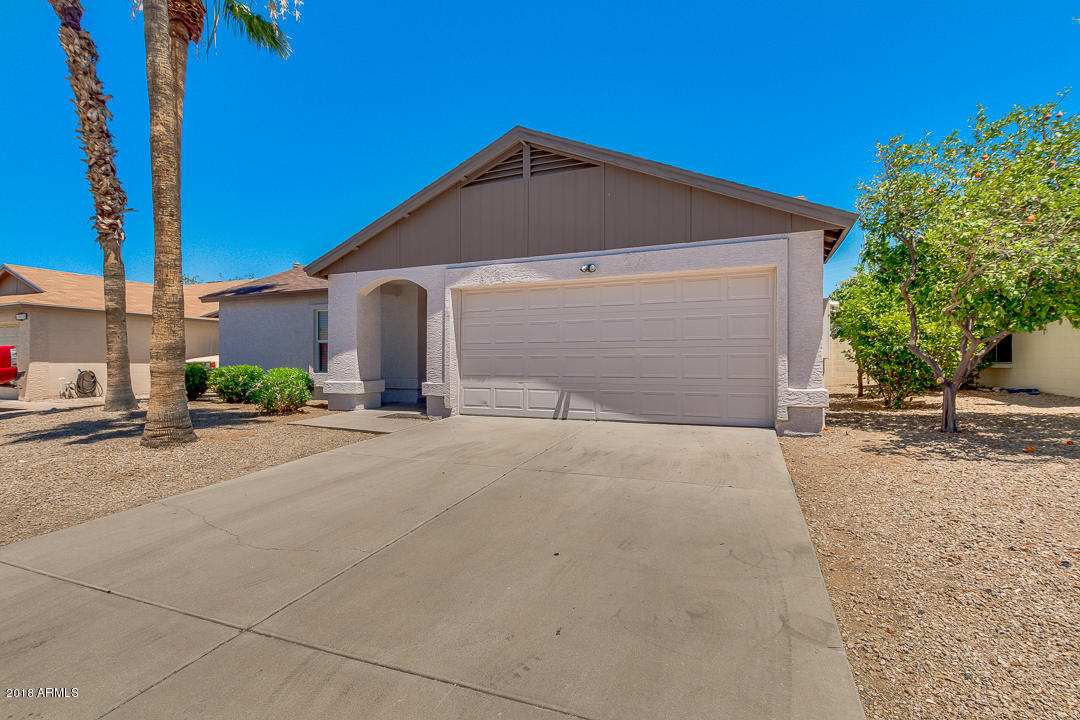 6320 Casper Road Mesa, AZ 85205 - Photo 3 of 35 a front view of a house with a yard and garage