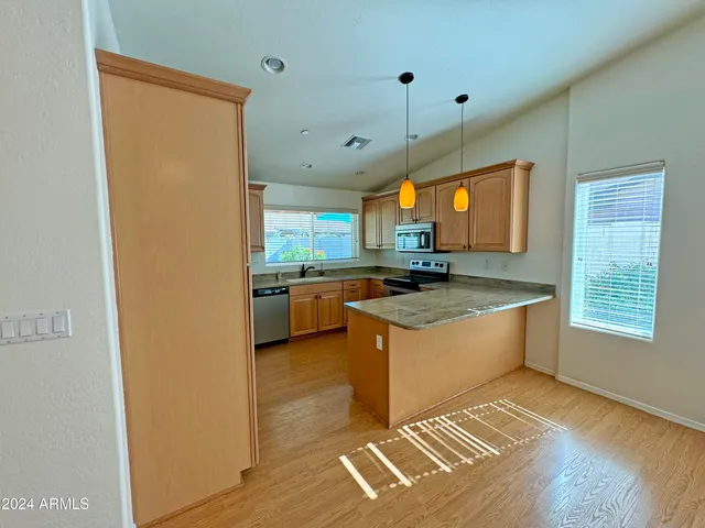 a view of a kitchen with wooden floor and a sink