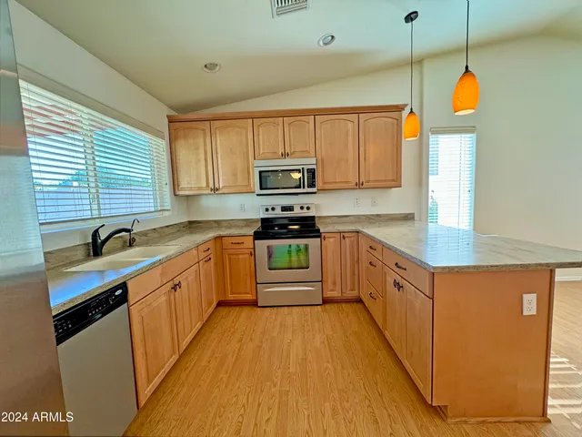 a kitchen with stainless steel appliances granite countertop a stove a sink and a refrigerator