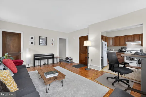a living room with furniture kitchen view and a window