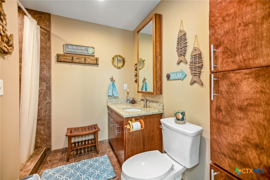 265 Coastal Oaks Loop Port O'Connor, TX 77982 - Photo 11 of 48 a bathroom with a toilet a sink and a mirror