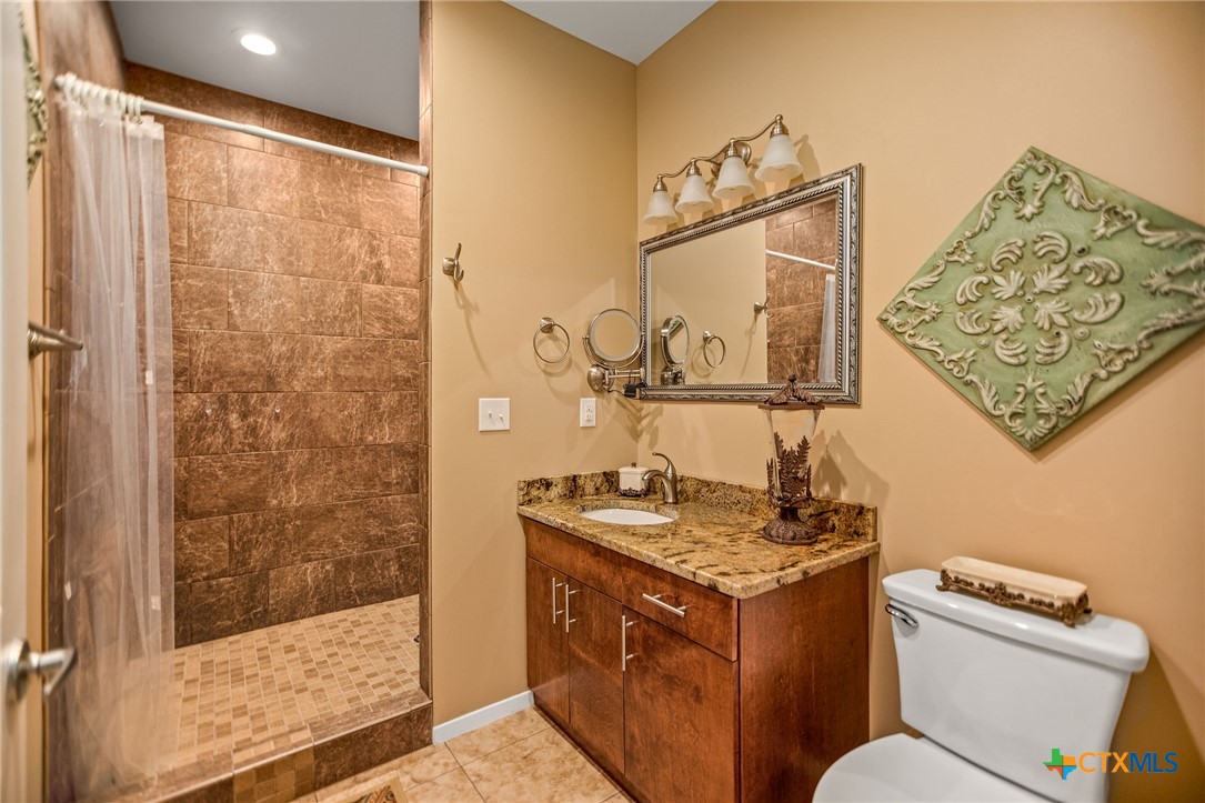 265 Coastal Oaks Loop Port O'Connor, TX 77982 - Photo 30 of 48 a bathroom with a granite countertop sink mirror vanity and toilet