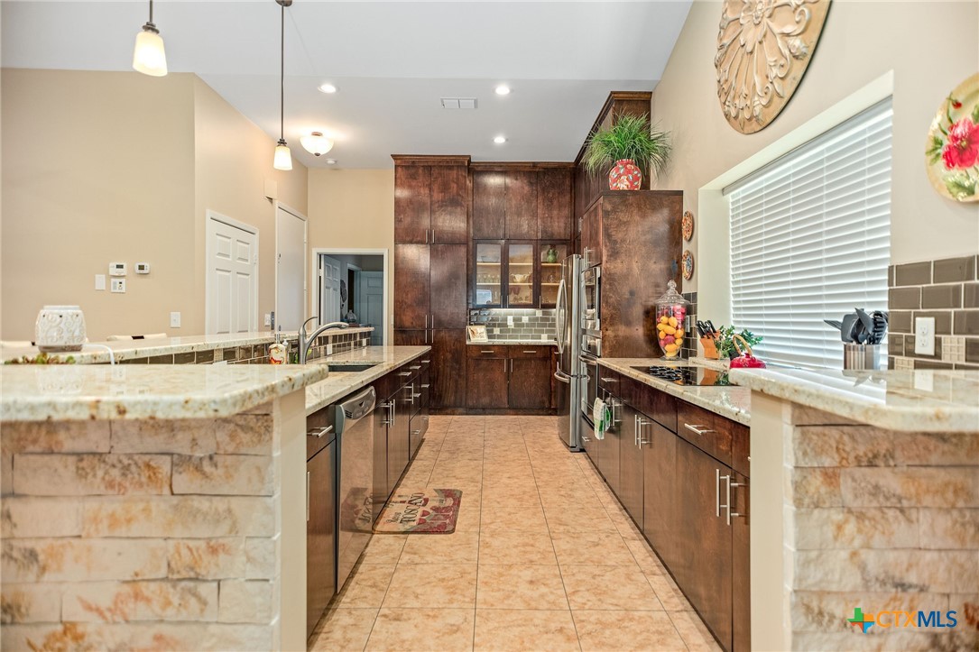 265 Coastal Oaks Loop Port O'Connor, TX 77982 - Photo 45 of 48 a large kitchen with stainless steel appliances kitchen island granite countertop a large counter top a stove a sink and a refrigerator