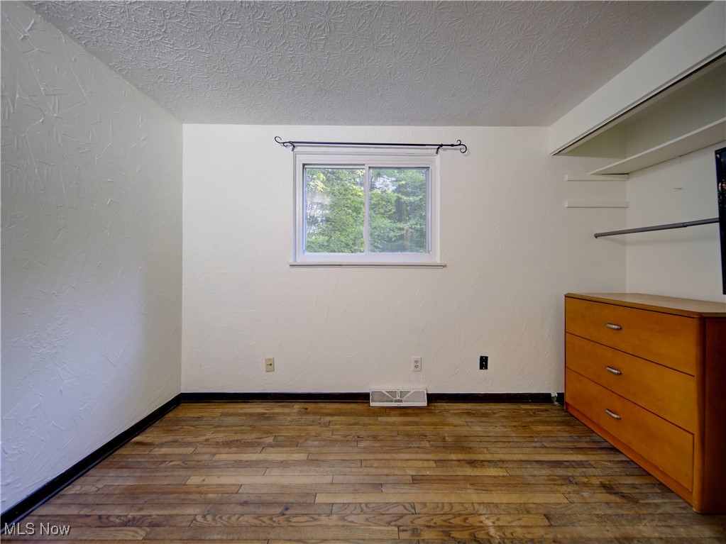 8075 Mulberry Road Chesterland, OH 44026 - Photo 27 of 38 Unfurnished room with a textured wall, dark wood-style floors, and a textured ceiling
