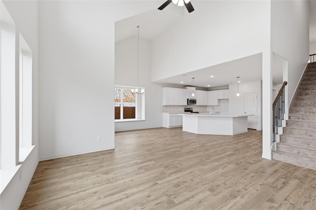 3737 Pitchfork Terrace Anna, TX 75409 - Photo 11 of 33 Expansive great room featuring wood-finish flooring, vaulted ceilings, and large windows
