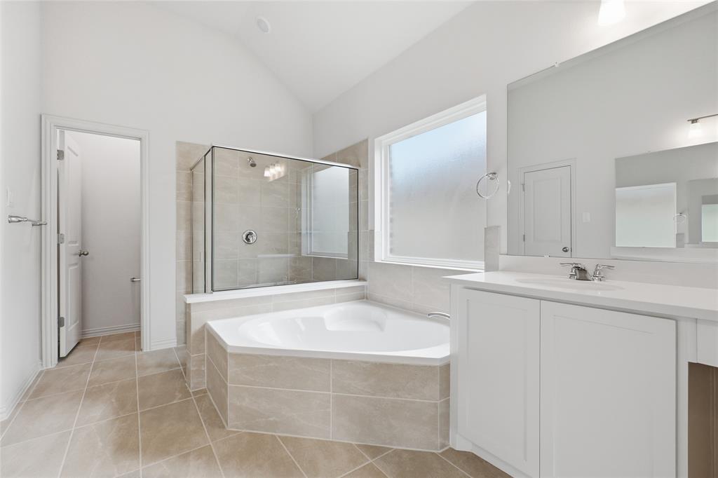 3737 Pitchfork Terrace Anna, TX 75409 - Photo 16 of 33 Spacious bathroom featuring a corner soaking tub, glass-enclosed shower, dual vanity with white cabinetry, large vanity mirror, and vaulted ceiling