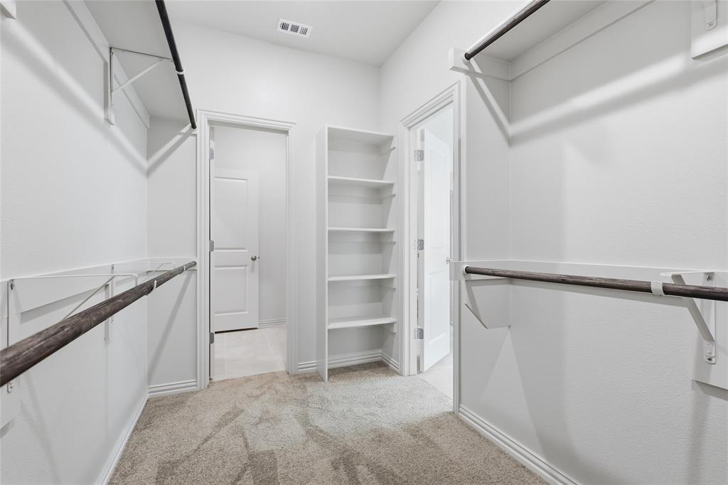 3737 Pitchfork Terrace Anna, TX 75409 - Photo 19 of 33 Walk-in closet featuring carpet flooring, built-in shelving, two hanging rods, and bright white walls