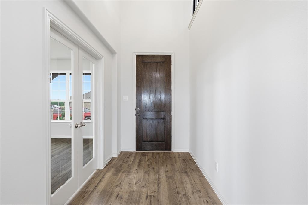 3737 Pitchfork Terrace Anna, TX 75409 - Photo 2 of 33 Entryway featuring wood-finish flooring, a dark wood paneled door, and tall white walls