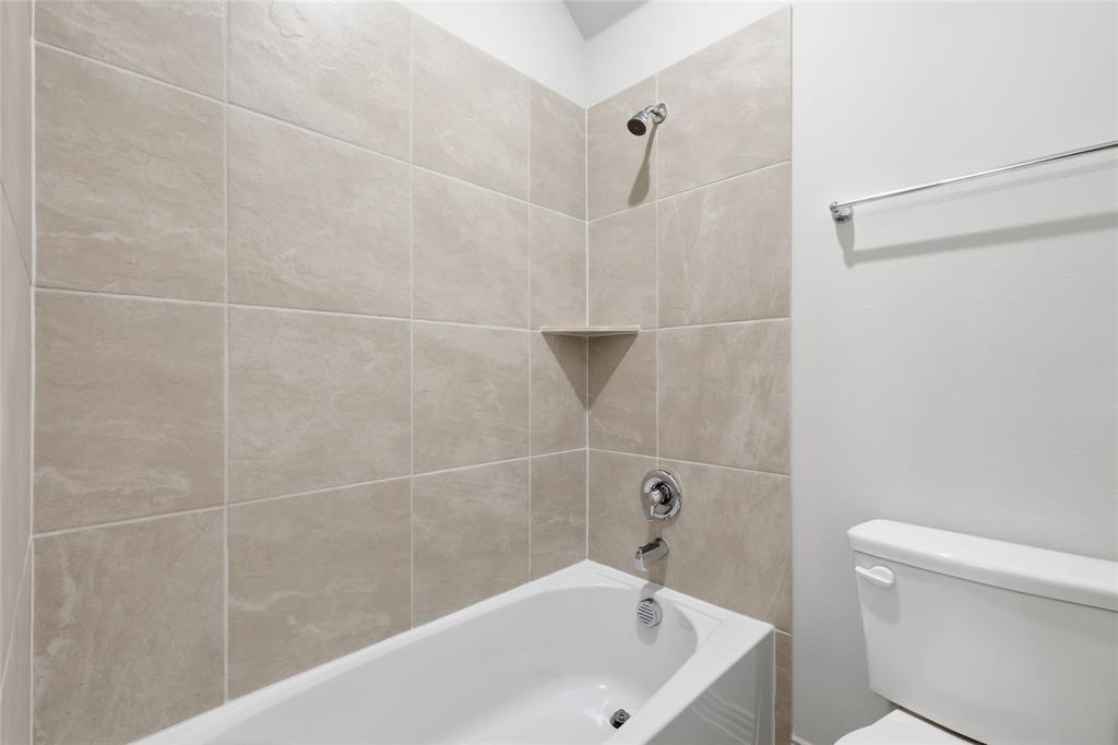 3737 Pitchfork Terrace Anna, TX 75409 - Photo 25 of 33 Bathtub and shower combination featuring neutral-toned tile surround with a corner shelf