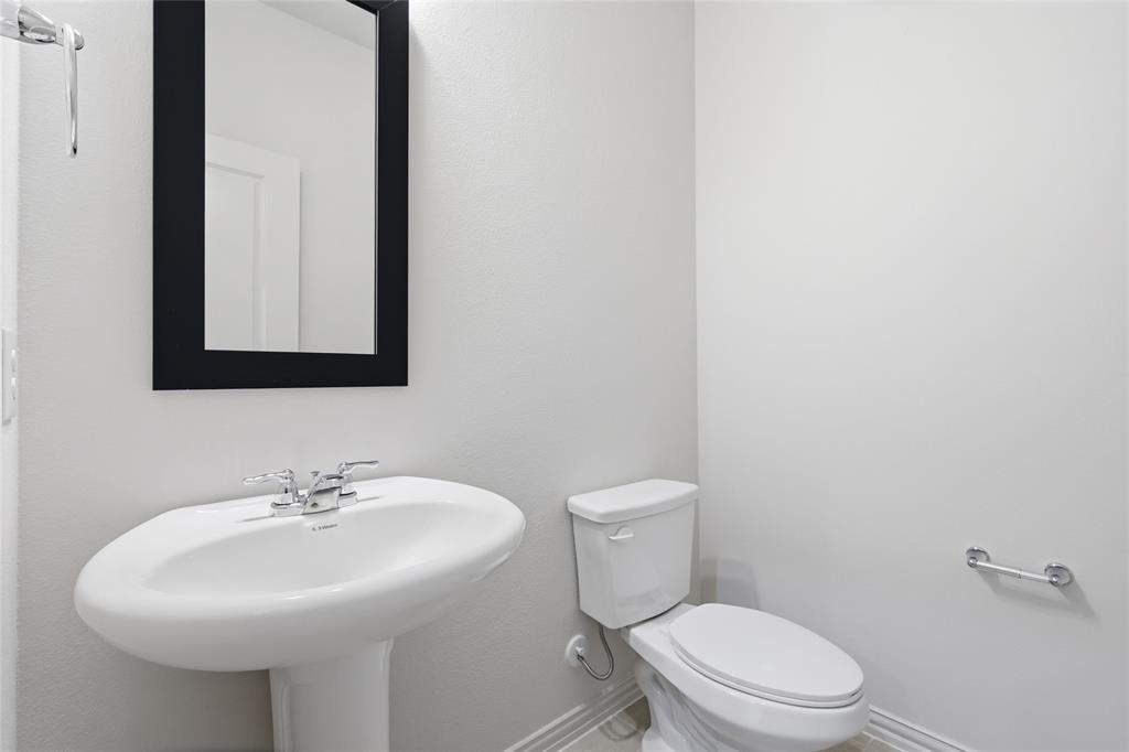 3737 Pitchfork Terrace Anna, TX 75409 - Photo 26 of 33 Pedestal sink with chrome faucet, complemented by a rectangular framed mirror and a modern toilet