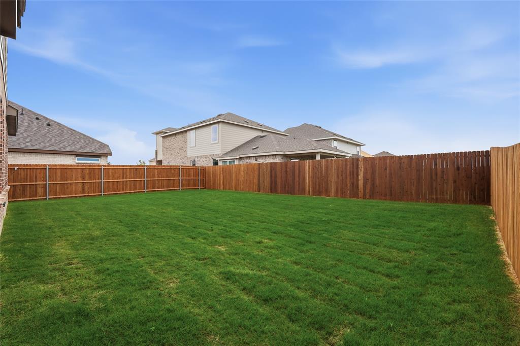 3737 Pitchfork Terrace Anna, TX 75409 - Photo 30 of 33 Spacious backyard featuring a lush green lawn, full wood privacy fencing, and brick exterior detailing
