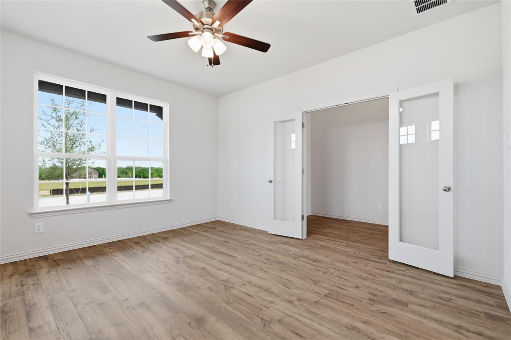 3737 Pitchfork Terrace Anna, TX 75409 - Photo 5 of 33 Spacious room with wood-finish flooring, a large multi-pane window, and a ceiling fan