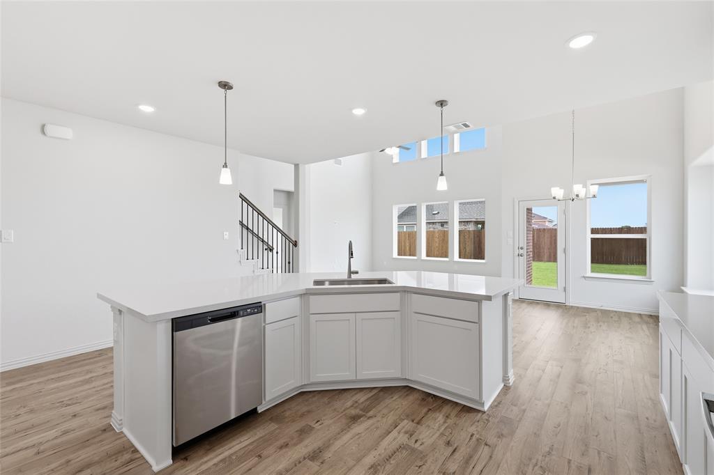 3737 Pitchfork Terrace Anna, TX 75409 - Photo 7 of 33 Spacious kitchen island featuring a stainless steel dishwasher, undermount sink with a gooseneck faucet, and two pendant lights