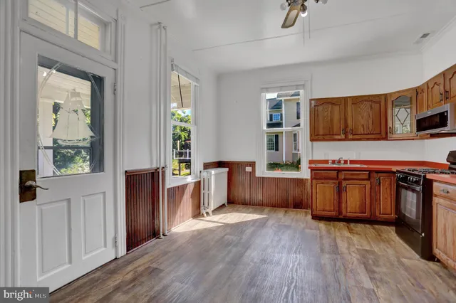 a kitchen with stainless steel appliances a refrigerator a stove a sink dishwasher a refrigerator with a dining table and chairs