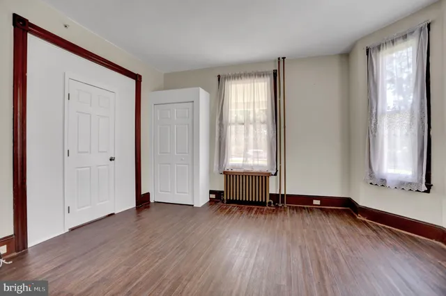 a view of a hallway with wooden floor and stairs