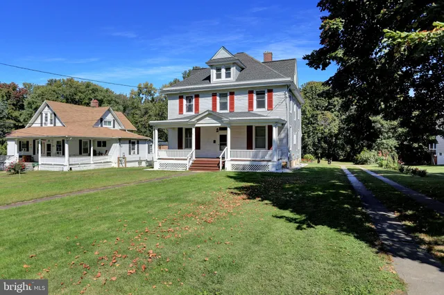a front view of a house with yard and green space