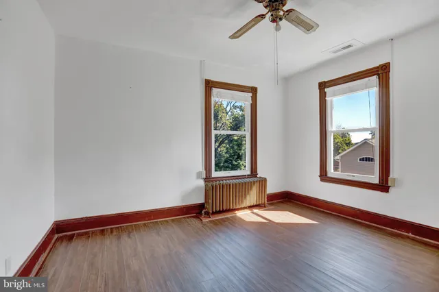 an empty room with wooden floor and closet