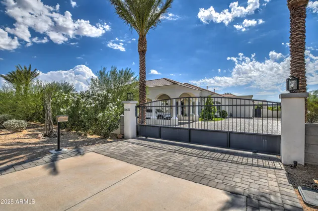 a front view of a house with a yard and potted plants
