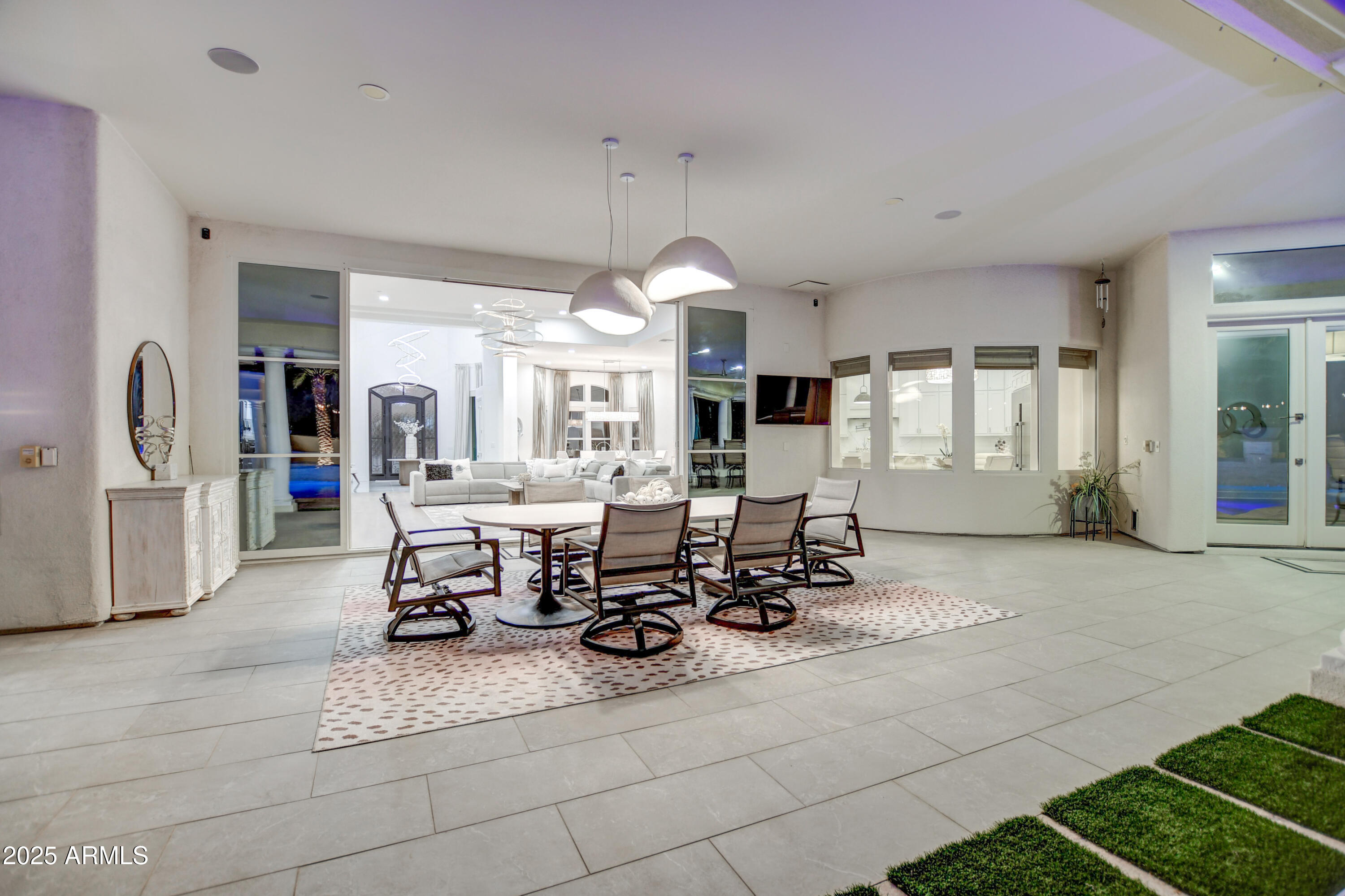 10651 East Cactus Road Scottsdale, AZ 85259 - Photo 51 of 126 a view of a dining room and livingroom with furniture wooden floor a rug a fireplace and windows