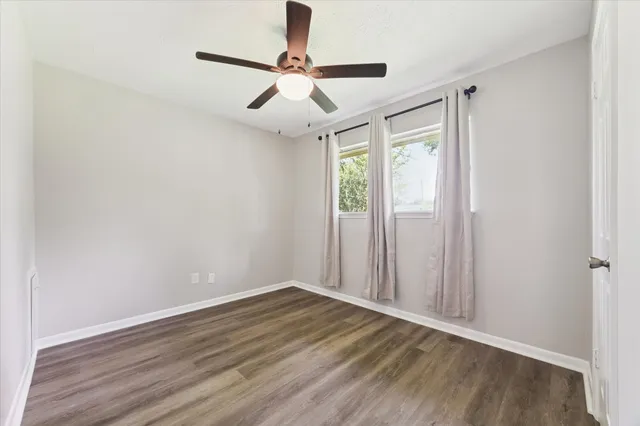 a view of room with wooden floor and ceiling fan