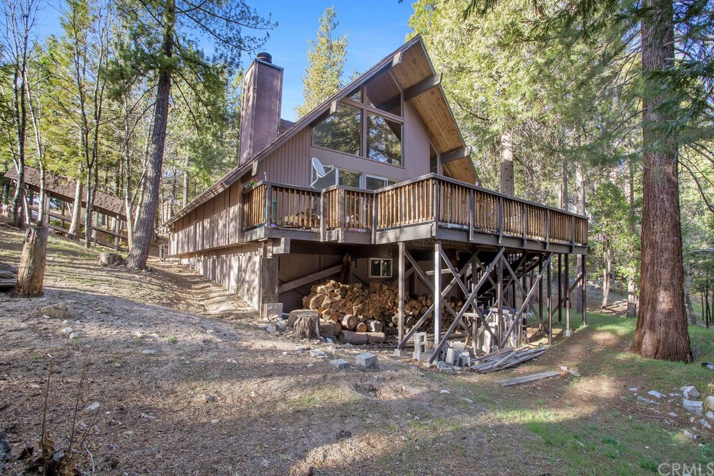 a view of a house with a large tree and wooden fence