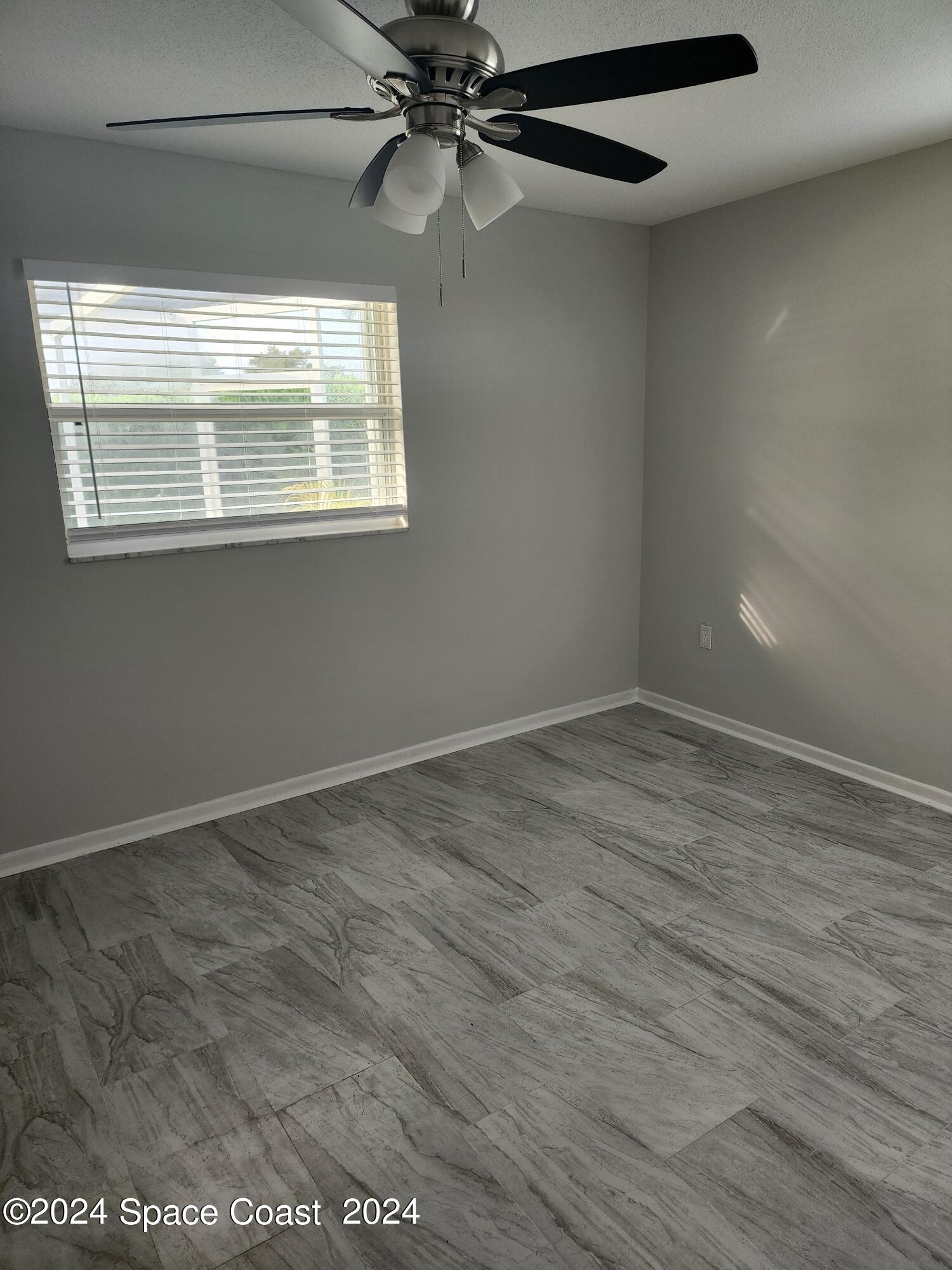 1725 Reef Court Merritt Island, FL 32952 - Photo 17 of 26 a view of an empty room with wooden floor and a window