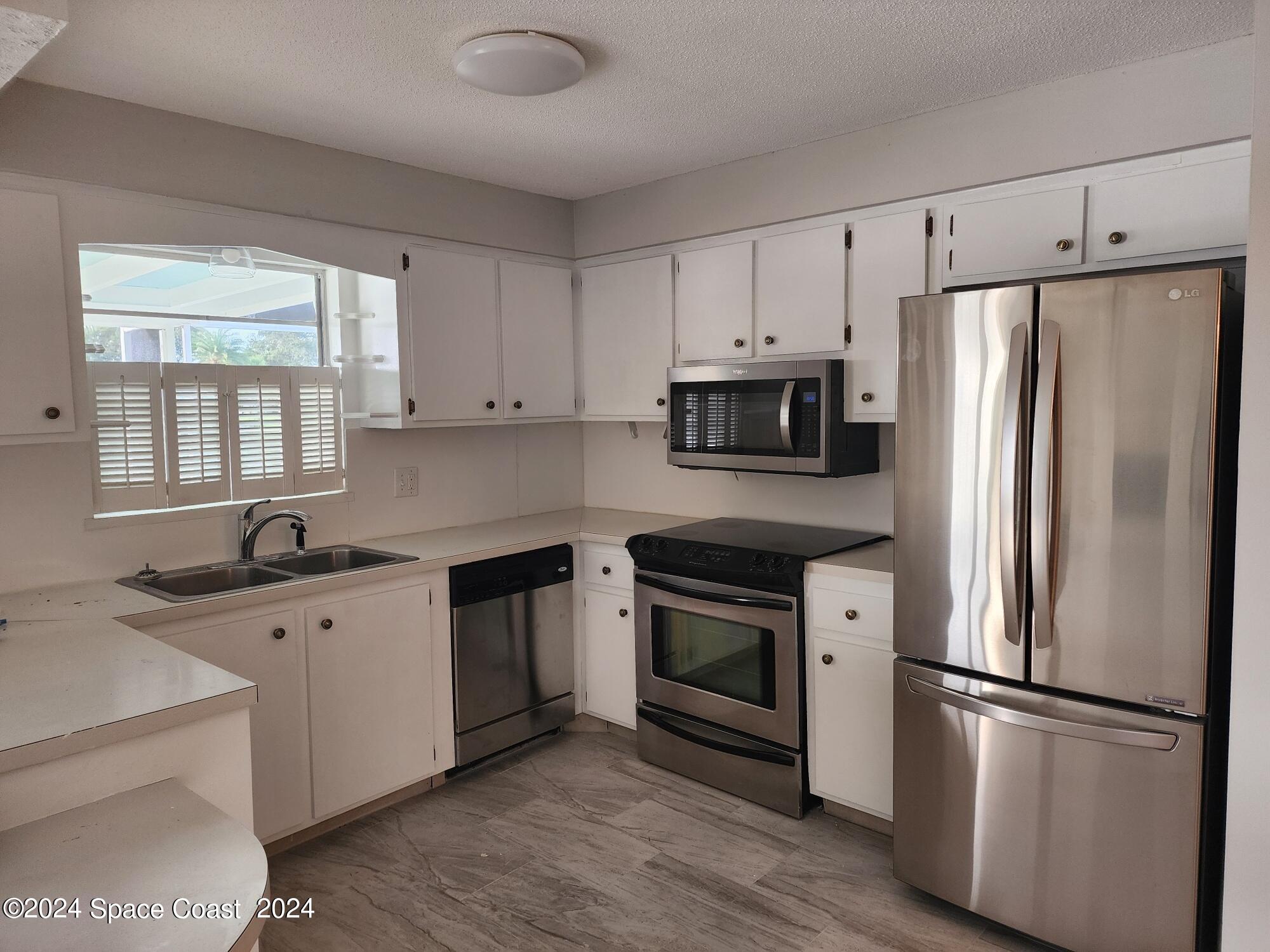 1725 Reef Court Merritt Island, FL 32952 - Photo 7 of 26 a kitchen with cabinets stainless steel appliances a sink and a window