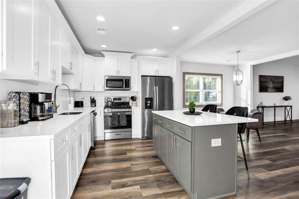 128 Nathan Road Southwest Atlanta, GA 30331 - Photo 13 of 36 a kitchen with stainless steel appliances a stove top oven a sink dishwasher a refrigerator and white cabinets with wooden floor