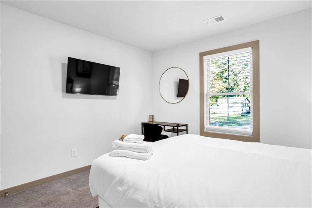128 Nathan Road Southwest Atlanta, GA 30331 - Photo 24 of 36 a bedroom with a bed a window and a flat screen tv