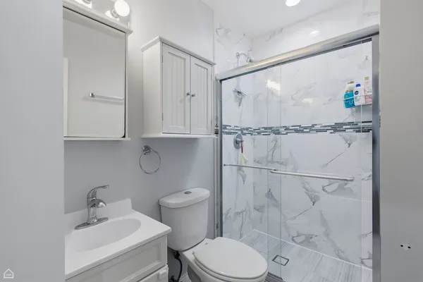 a bathroom with a toilet a sink and shower