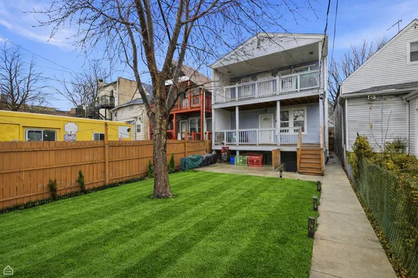 a view of a house with backyard and wooden fence