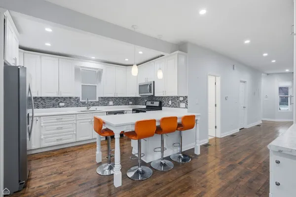 a kitchen with stainless steel appliances granite countertop a refrigerator and a stove top oven