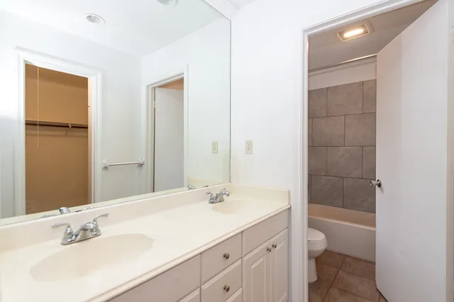 a bathroom with a bathtub shower sink vanity and toilet